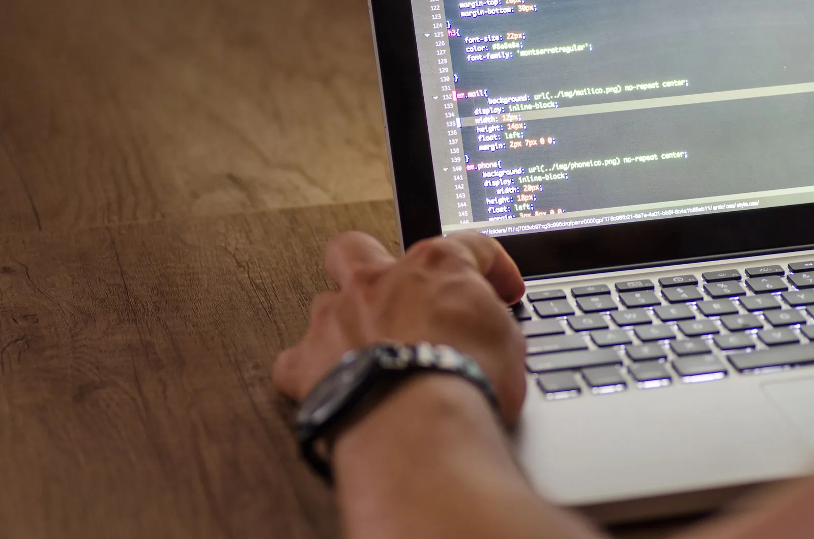Developer comparing automation workflow code on laptop terminal with multiple SaaS integration dashboards