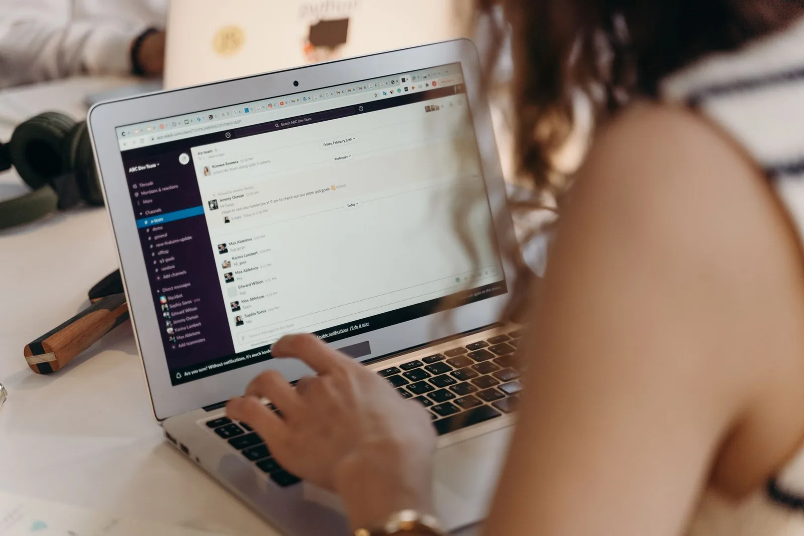 Developer working in Slack on a laptop while building an AI teammate integration with Claude