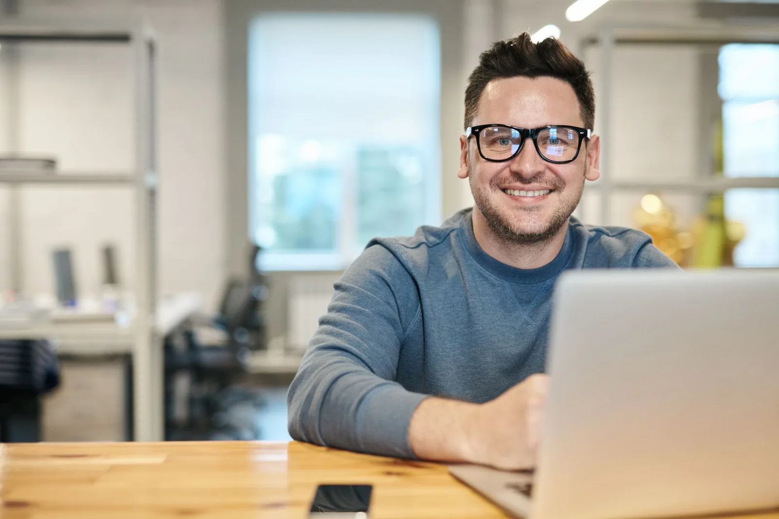 Non-technical founder reviewing AI automation workflows on a laptop at a modern office desk
