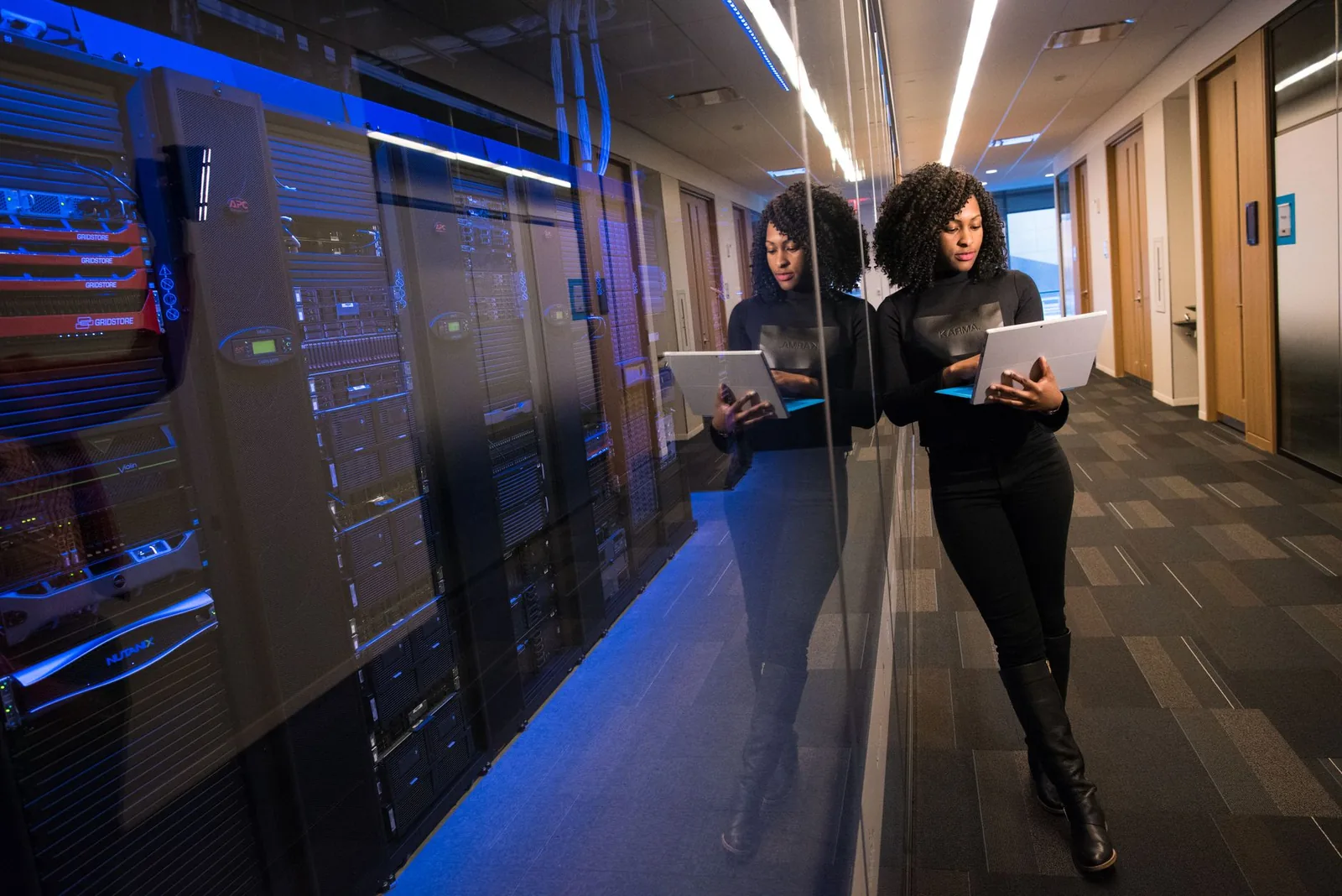 Developer monitoring AI agent costs and security metrics on multiple terminal screens in a dark office