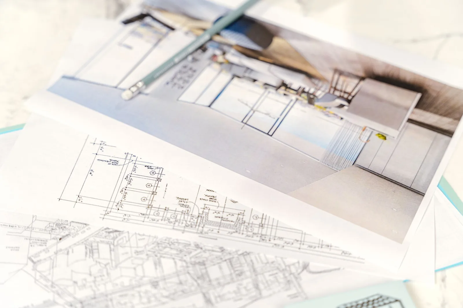 Scattered construction blueprints and spec sheets with handwritten annotations on a desk